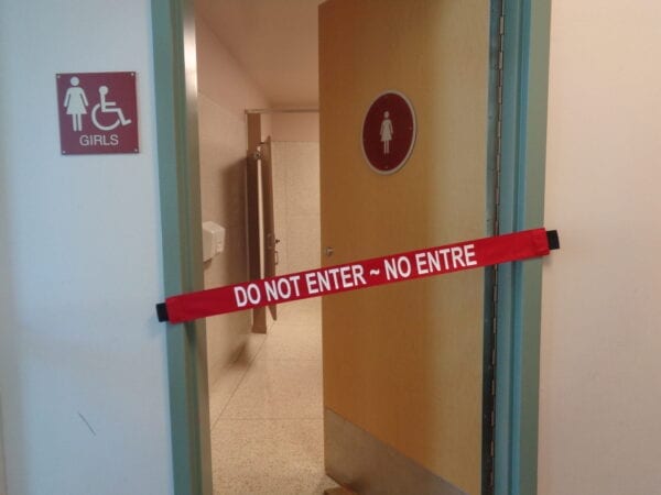 A “Do Not Enter” Banner On a Girls’ Bathroom Door