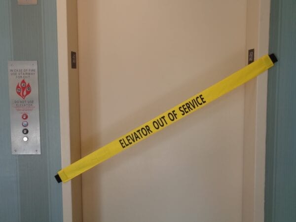 Yellow banner with black text sticked to the elevator