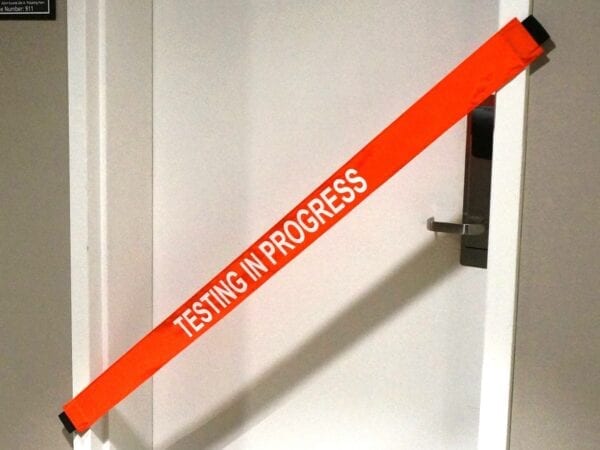 A “Testing in Progress” Banner Place on a Door