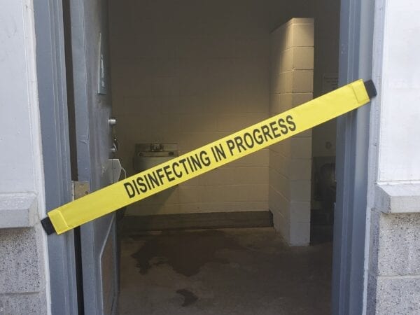 A “Disinfecting in Progress” Signage on a Bathroom Doorway